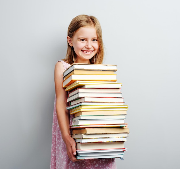 Écolière tenant une pile de livres