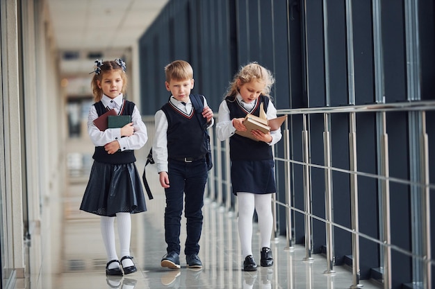 Écoliers en uniforme ensemble dans le couloir Conception de l'éducation