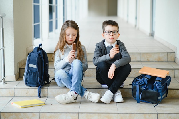 Écoliers en uniforme ensemble dans le couloir Conception de l'éducation