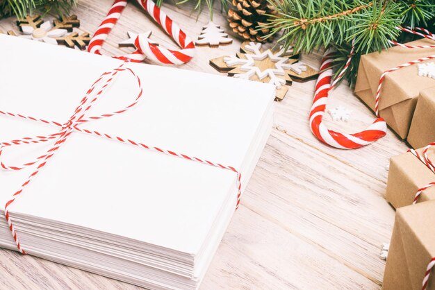 Photo colis dans une enveloppe avec des branches de sapin et une décoration de noël sur un fond en bois tonique