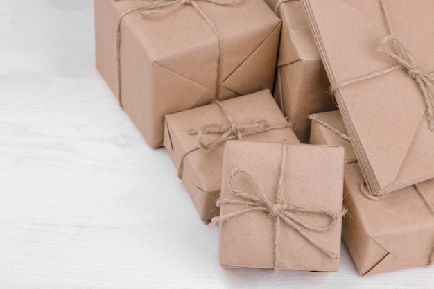 Colis postaux. boîtes enveloppées dans du papier kraft sur une table en bois blanche. concept de courrier ou de livraison