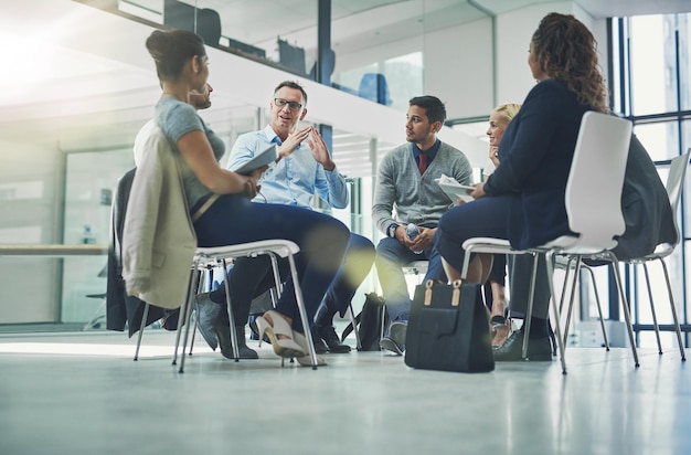 Collaboration en équipe et planification stratégique de l'équipe commerciale travaillant ensemble à l'intérieur Employés de bureau modernes parlant et assis dans une réunion de groupe Des collègues travaillent et parlent d'un projet