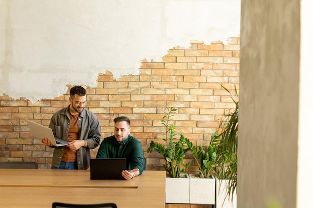 Collaboration en mouvement Professionnels travaillant ensemble dans un bureau moderne avec des murs de briques