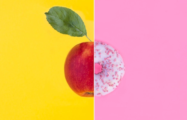 Collage de beignet avec glaçage rose et pomme rouge sur fond coloré Espace de copie