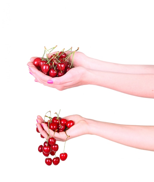 Collage de cerises dans une main féminine sur fond blanc