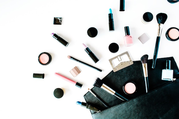 Collage de cosmétiques féminins à plat avec rouge à lèvres, pinceau sur blanc