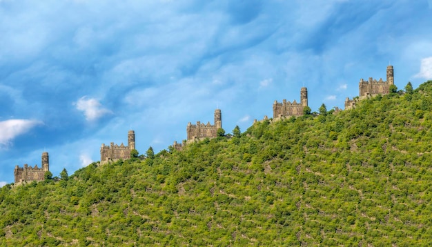 Collage avec un vieux château à flanc de montagne