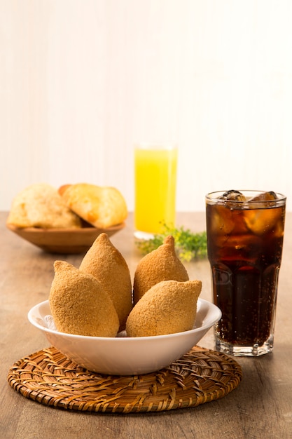 Collation brésilienne au poulet frit, populaire lors des fêtes locales.