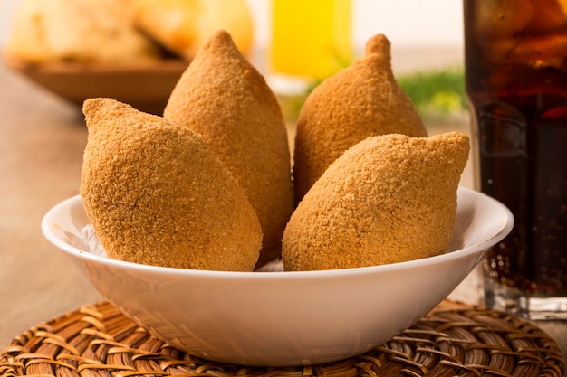 Collation brésilienne au poulet frit, populaire lors des fêtes locales.