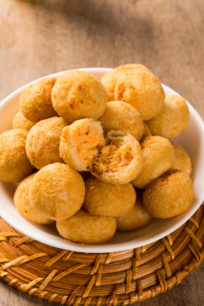 Collation brésilienne. boulette de poulet au caillé sur fond de bois.