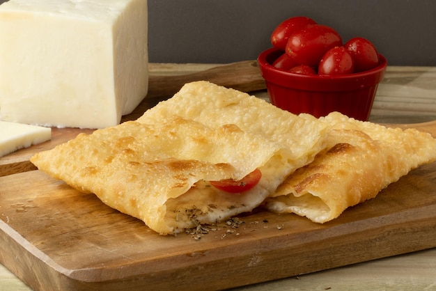 Collation brésilienne délicieuse et traditionnelle pastel de fromage et de tomate