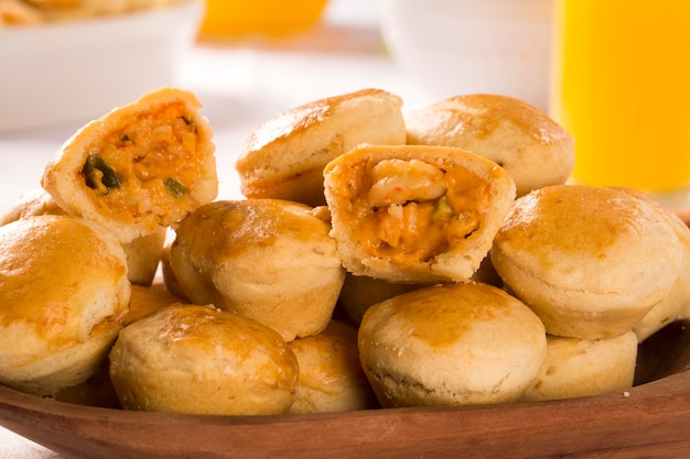 Collation brésilienne Empada. Tarte aux crevettes sur plaque blanche sur fond de bois