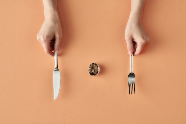 Collation saine de noix et mains avec fourchette et couteau isolé