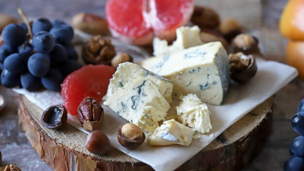 Photo collation saine sur un plateau en bois. fromage, noix et fruits. régime céto. collation keto.