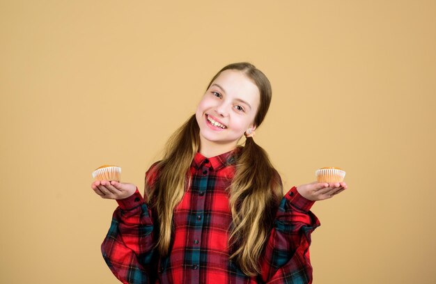 Collation savoureuse Les enfants adorent les muffins Obsédé par la nourriture maison Régime alimentaire sain et calorique Muffins délicieux Fille enfant mignon mangeant des muffins ou un cupcake Dessert sucré Recette culinaire