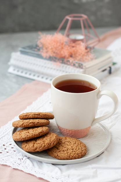 Une collation savoureuse: une tasse de thé et une assiette de biscuits.