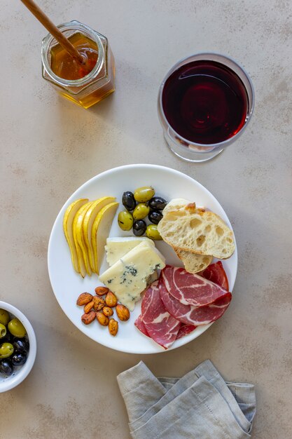 Collation de vin. Prosciutto, jambon de Parme, amandes, olives, baguette, fromage bleu. Antipasti.
