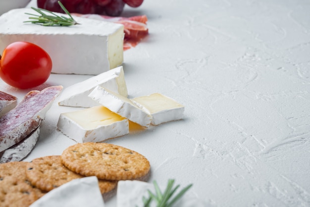 Des collations espagnoles, du fromage de viande, des herbes, sur table blanche