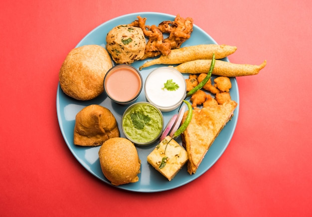 Les collations indiennes à l'heure du thé en groupe comprennent Veg Samosa, Kachori, kachaudi, aloo bonda, khaman dhokla, pain, oignon, piment et moong pakora, pakoda, bhaji, bhajji, Bhajiya, bajji avec sauces