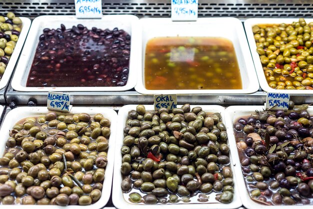 Photo collations mélangées d'olives dans des plateaux d'exposition au marché barcelone espagne