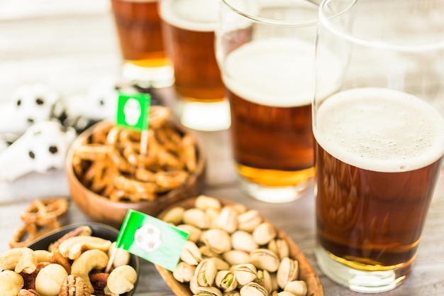 Des collations salées et de la bière sur la table pour une fête de football.