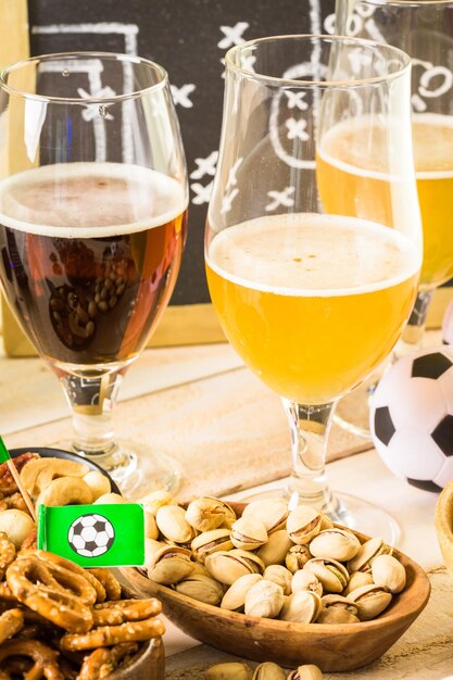 Des collations salées et de la bière sur la table pour une fête de football.