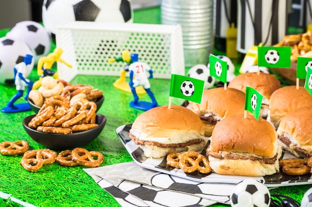 Des collations salées et de la bière sur la table pour une fête de football.