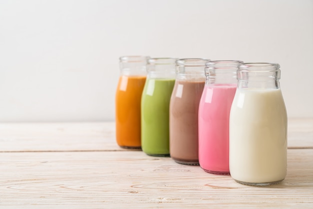 Collection de boisson. Thé au lait thaïlandais, thé vert matcha latte, café, lait au chocolat, lait rose et lait frais en bouteille sur table en bois