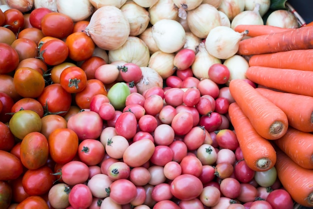 Une collection de carottes, tomates et oignons