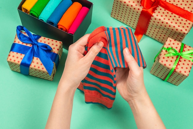 Collection colorée de chaussettes en coton comme cadeau dans les mains de la femme. Cadeau.