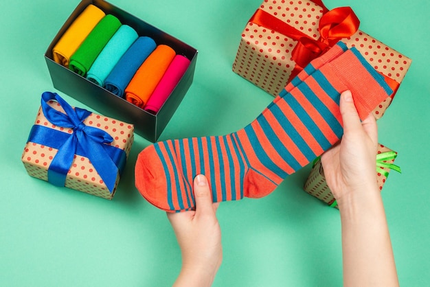 Collection colorée de chaussettes en coton comme cadeau dans les mains de la femme