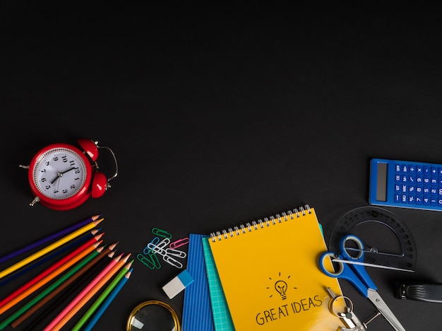 Collection colorée de fournitures scolaires sur fond noir. retour à l'école. vue de dessus