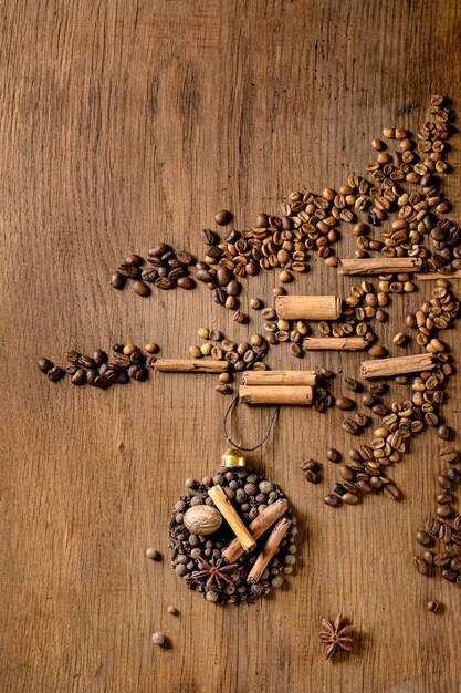 Collection d'épices aromatiques sous forme de boules de Noël sur l'arbre de Noël à partir de différents grains de café sur fond de bois foncé. Les amateurs de café de salutations de Noël. Espace de copie