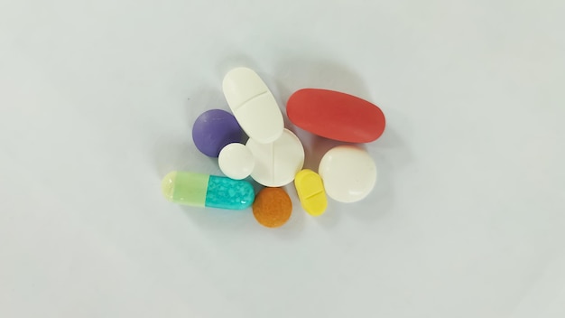 une collection de médicaments composée de comprimés, de pilules et de gélules, sur un fond blanc