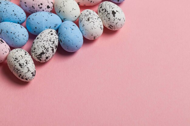 Une collection d'oeufs de pâques sur fond rose pastel