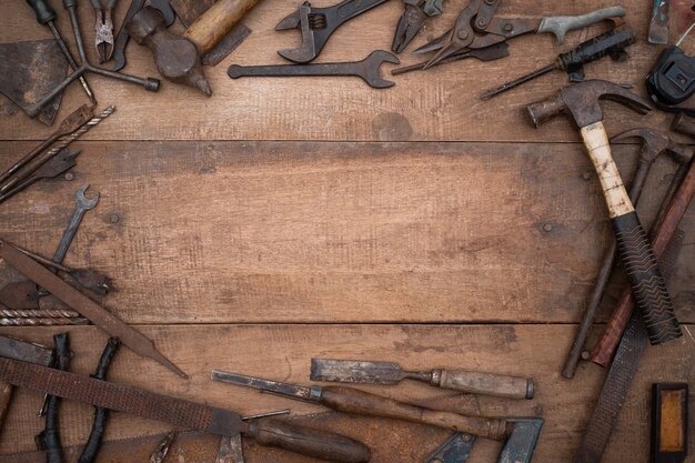 Collection d'outils à main de menuiserie antique sur un établi en bois ancien avec espace copie vierge