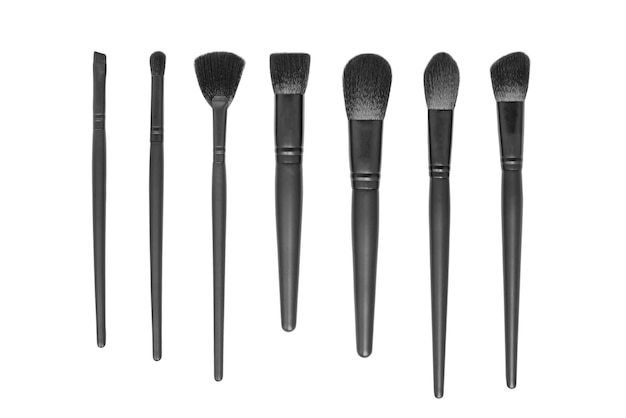 Collection de pinceaux de maquillage noirs isolés sur fond blanc mise à plat