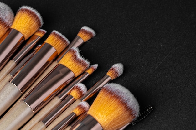 Collection de pinceaux de maquillage sur une surface noire