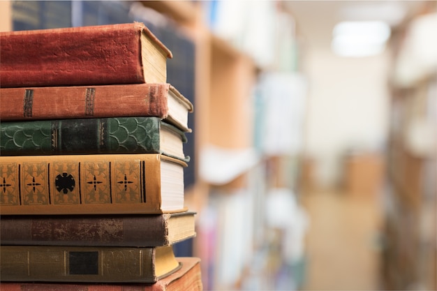 Collection de vieux livres sur un bureau en bois au fond de la bibliothèque