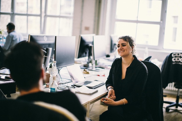 Des collègues d'affaires souriants discutant assis au bureau