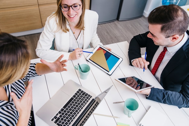 Photo collègues amicaux avec des appareils au bureau