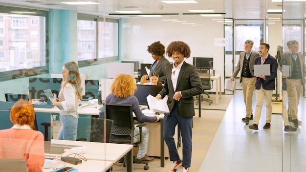 Des collègues arrivent au bureau et s'assoient sur le bureau.