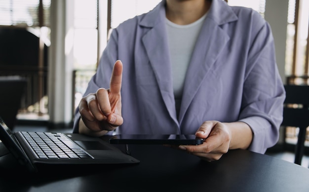 Collègues asiatiques homme et femme discutant et travaillant avec un ordinateur portable sur un bureau au bureau