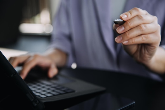 Collègues asiatiques homme et femme discutant et travaillant avec un ordinateur portable sur un bureau au bureau