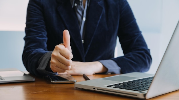 Collègues asiatiques homme et femme discutant et travaillant avec un ordinateur portable sur un bureau au bureau