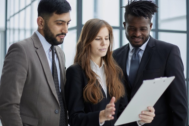 Collègues détenant des fichiers avec rapport d'activité et le lisant ensemble au travail