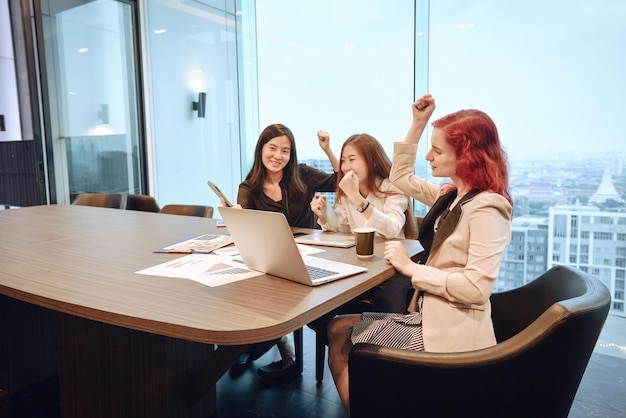 Des collègues heureuses assises dans une salle de conférence au bureau.