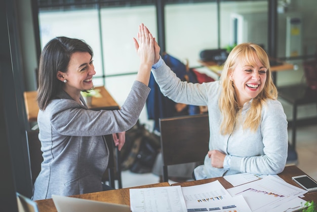 Des collègues heureux se battent la main au bureau.