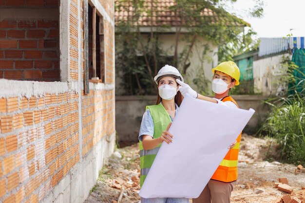 Les collègues ingénieurs masculins et féminins à la recherche et à la découverte de la construction du bâtiment