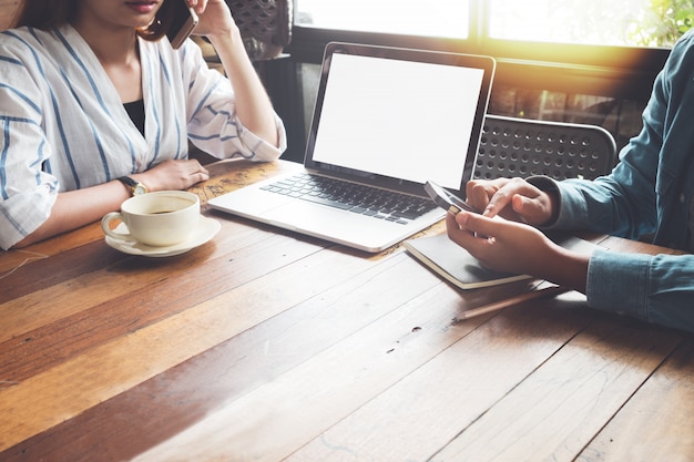 Collègues de jeunes femmes d&#39;équipe de travail travaillant avec ordinateur portable, téléphone mobile.